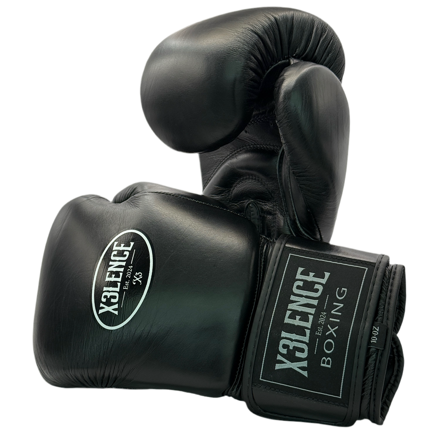 Zwarte X3LENCE bokshandschoenen van echt leer met wit logo – premium kwaliteit beschikbaar in 10 oz, 12 oz, 14 oz en 16 oz. Ontworpen voor comfort, duurzaamheid en optimale bescherming bij bokstraining en sparring.